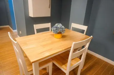 a wooden table with a vase of flowers on it at ALTEAN Apartments - Lydia Room in Manila