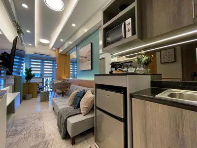a kitchen and a living room with a couch at SMDC Fame Residence luxurious family suite condo near mrt in Manila
