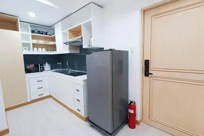 a kitchen with a stainless steel refrigerator next to a door at Travelers Inn - Cozy Capsule Bunks, Makati in Manila