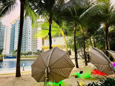 a beach with palm trees and umbrellas in the sand at Azure cozy corners in Manila