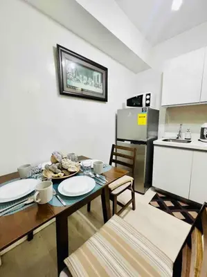 a kitchen with a table and chairs and a kitchen with a table and a table at Azure cozy corners in Manila