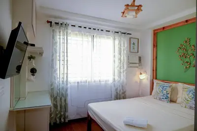 a small bedroom with a bed and a window at House of Citiflora Unit B in Manila