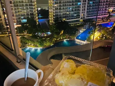 a table with a plate of cake and a cup of coffee at Azure Urban Resort a13 near airport wavepool in Manila