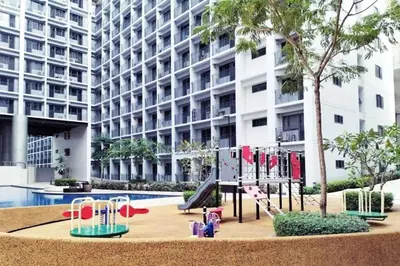 a playground in front of a large building at Shabby Chic & Contemporary Condo in Manila