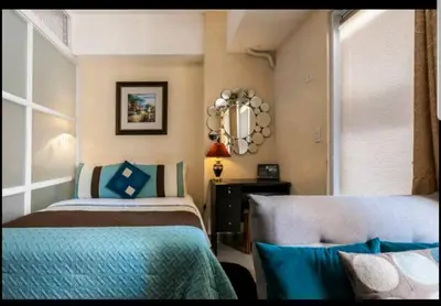 a bedroom with two beds and a mirror at Venice Luxury Residences, Tower B, McKinley Hill, Taguig in Manila