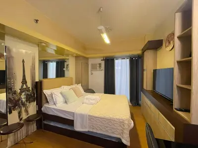 a bedroom with a large bed and a television at Manila Bay Views City Delights Stay near St Lukes and US Embassy in Ermita Manila in Manila