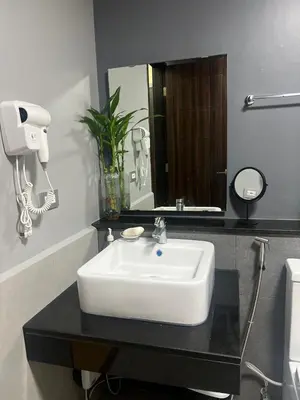 a bathroom with a white sink and a mirror at Sundawn RadianceManilaBay in Manila