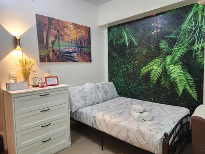 a bedroom with a bed and a painting on the wall at DG CONDOTEL @MANHATTAN PLAZA T2 STUDIO WITH BALCONY , 50 INCH TV AND UNLI WIFI @Araneta Cubao Quezon City Philippines in Manila