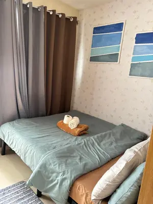 a bedroom with a bed with towels on it at JAL's Cozy Haven in Manila