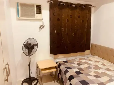 a small bedroom with a bed and a fan at SMDC Light Residences Condominium in Manila