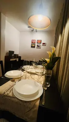 a table with plates and wine glasses on it at Modern Condo for Couple with Wi-Fi, Netflix & Kitchen, 1 min to MRT Boni in Manila