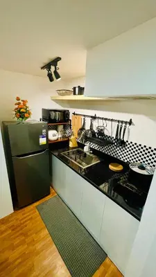 a kitchen with a black refrigerator and a sink at Modern Condo for Couple with Wi-Fi, Netflix & Kitchen, 1 min to MRT Boni in Manila