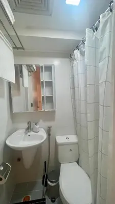 a small bathroom with a toilet and a sink at Modern Condo for Couple with Wi-Fi, Netflix & Kitchen, 1 min to MRT Boni in Manila