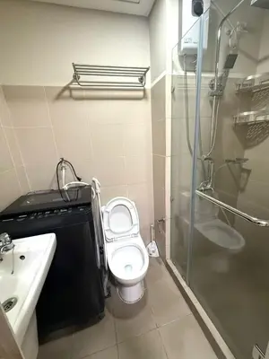 a bathroom with a toilet and a shower and a sink at Cozy Two Bedroom Family Suites at Coast Residences near PICC, WTC & MOA in Manila