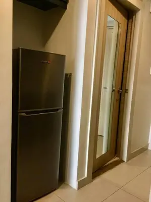 a refrigerator in a room next to a door at Cozy 1 Studio Room - The Residences BGC Taguig in Manila