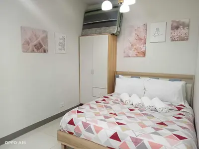 a bedroom with a bed with two slippers on it at Serendipity Suite at S Residences in Manila