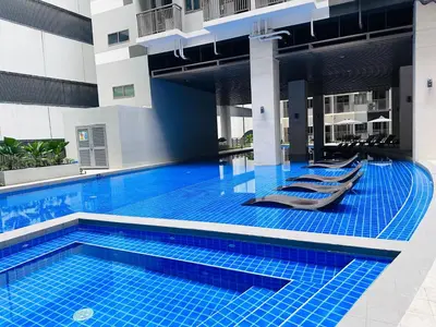 a swimming pool with lounge chairs in a building at Serendipity Suite at S Residences in Manila