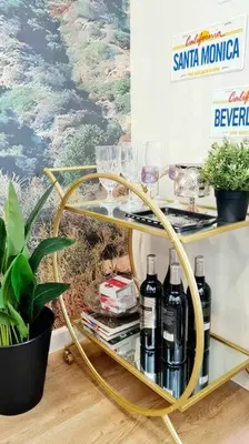 a shelf with wine bottles and glasses on it at California Themed Condo in BGC in Manila