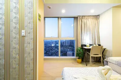 a bedroom with a bed and a desk and a window at Premium 3BR Suite UptownBGC w/ Bathtub & Balcony in Manila