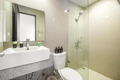 a bathroom with a toilet and a sink and a shower at Premium 3BR Suite UptownBGC w/ Bathtub & Balcony in Manila