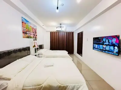 a bedroom with two beds and a flat screen tv at Katrina Suite infront of Mall of Asia and Bay area in Manila