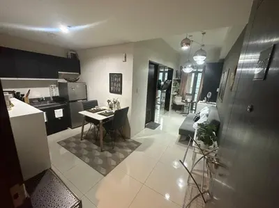 a kitchen and a living room with a table at Condo in BGC near Grand Hyatt in Manila