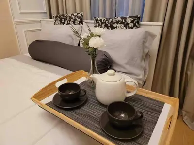 a tray with a tea pot and cups on a bed at Condo in BGC near Grand Hyatt in Manila