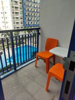 a balcony with a table and chairs and a view of a pool at Apartment By Douie At Sea Residences in Manila
