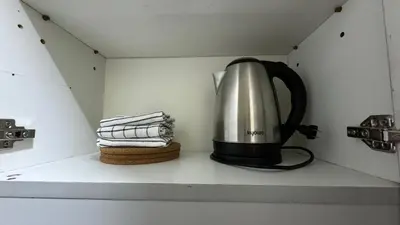 a tea kettle sitting on a shelf in a kitchen at Toby’s Crib at San Lorenzo Place in Manila