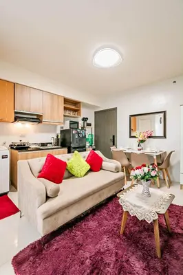 a living room with a couch and a kitchen at Coho The Hermosa - Staycation Studio Unit and Balcony View with Swimming Pool and Open Court access in Manila