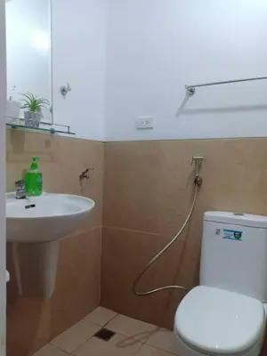 a bathroom with a white toilet and a sink at Humble Abode de Gloria in Manila