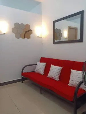 a red couch in a room with a mirror at Humble Abode de Gloria in Manila