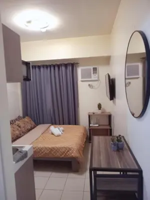 a small room with a bed and a mirror at Urban Deca Tower Edsa Mandaluyong Staycation Condotel in Manila