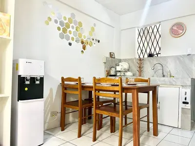 a kitchen with a wooden table and chairs at Suite Dreams Staycation - Cozy 2-BR - Wi-Fi Garden Kitchen in Dasmariñas