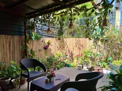 a patio with chairs and potted plants and a fence at Suite Dreams Staycation - Cozy 2-BR - Wi-Fi Garden Kitchen in Dasmariñas