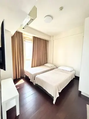 a hospital room with two beds and a television at 2 Bedroom Loft at Twin Oaks Place in Manila