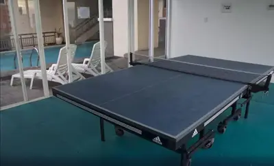 a ping pong table in a room with two chairs at Book Now for Free Pool And Sauna Access Inside Prime Location Of Manila near US Embassy, NAIA, Makati, BGC, Mall of Asia, Chinatown. Immerse in Sea View Balcony for Limited Time Offer This Month Click Here Now in Manila