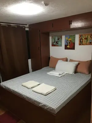a bed in a room with two towels on it at Stay in Manila, Cambridge Village in Cainta