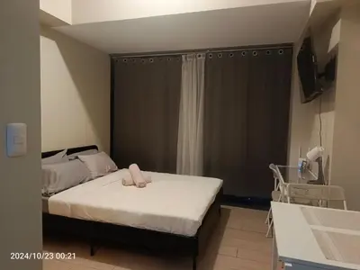 a bedroom with a bed with two pink towels on it at Eastwood Staycation Home with Stunning City View minimum 2nights stay in Manila