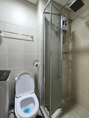 a bathroom with a toilet and a glass shower at Fame Residence 701 Tower 2 in Manila
