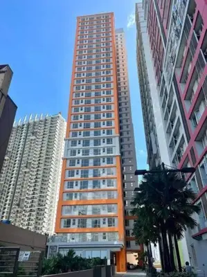 a tall apartment building in the middle of a city at Milia Condo w/ Free use of Swimming pool & Gym in Manila