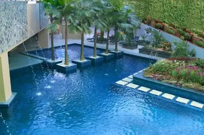 a pool in the middle of a building with palm trees at Milia Condo w/ Free use of Swimming pool & Gym in Manila