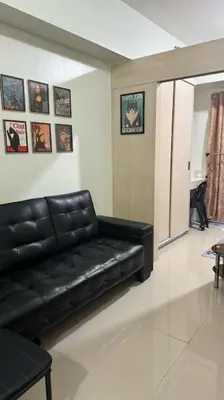 a black leather couch in a living room at Meowcation Condo in Makati in Manila