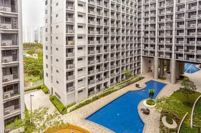an aerial view of a building with a swimming pool at ClaySky Staycation S2T1-Cozy & Homey 1BR Apartment near MOA facing Pool with Own Parking with Netflix, HBO Max YouTube Premium & up to 200mbps Wifi in Manila