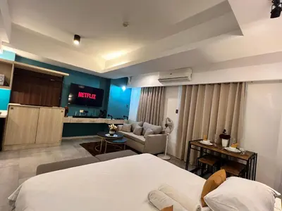 a hotel room with a bed and a tv at Comfty, Chic & Spacious Room with Parking & WiFi in Manila