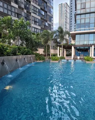 a large swimming pool in a city with tall buildings at Staycations Up Above 14 @ BGC 1BR in Manila