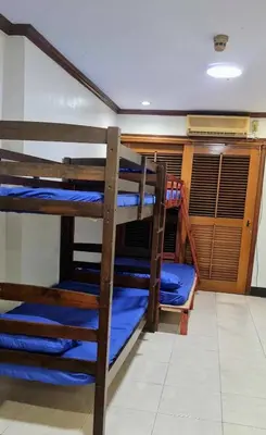 two bunk beds in a room with blue sheets at Makati Transient Condo 3BR with Balcony, Wifi in Manila