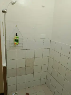 a bathroom with a shower with a bottle on the wall at Makati Transient Condo 3BR with Balcony, Wifi in Manila