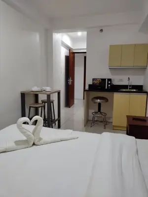 a bedroom with a bed with two white swans on it at Dian SUITES 1 in Manila