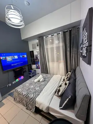 a bedroom with a large bed and a television at Buenbyahe Cozy Affordable Place at Urban Deca Tower along EDSA Shaw MRT walking distance in megamall in Manila